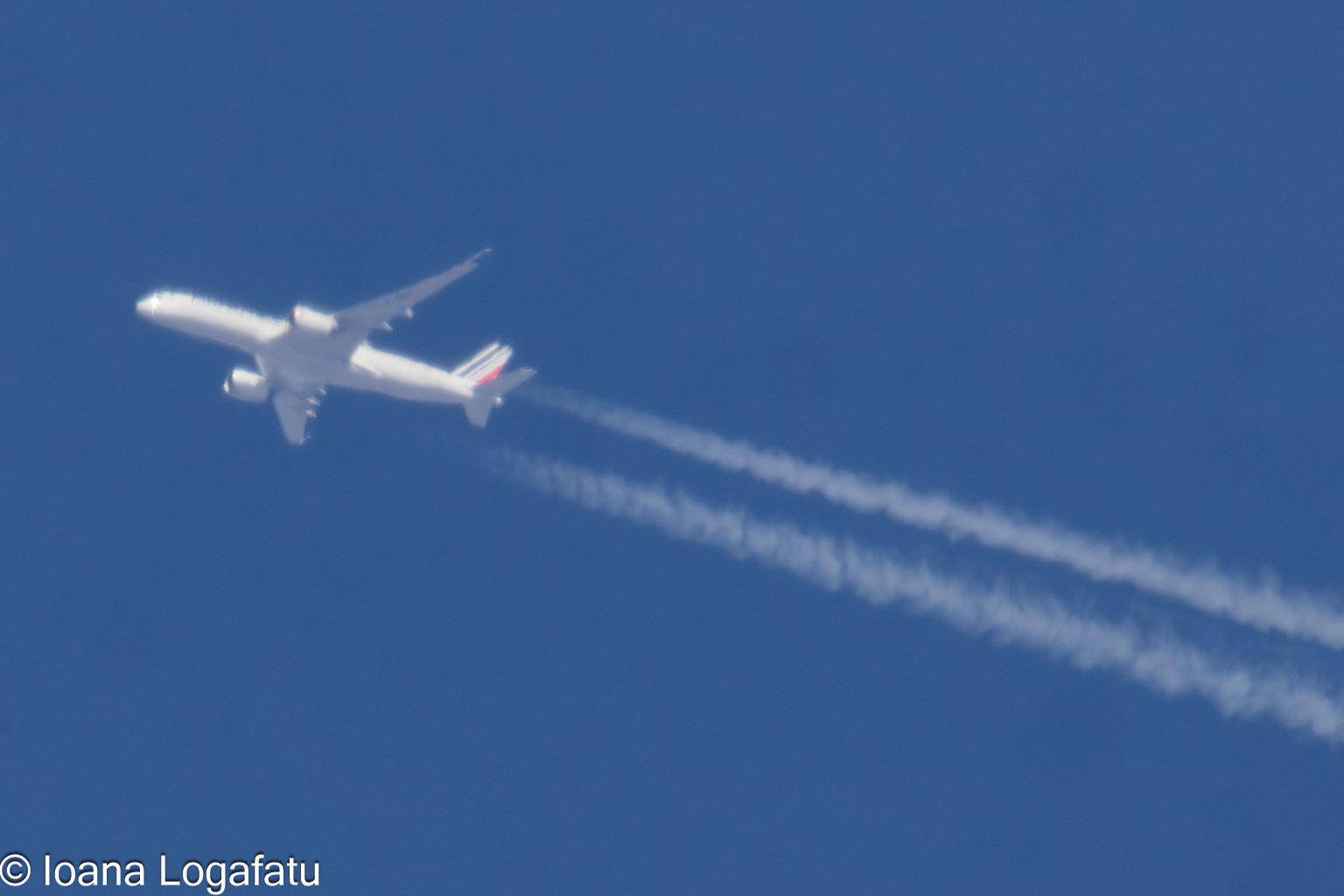 Airplane soaring through a clear blue sky